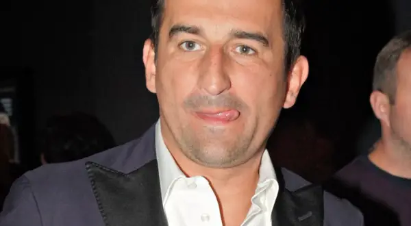 Michał Koterski, znany z wielu komediowych filmów, w tym "Kac Wawa", pokazuje język w zabawnym geście.
