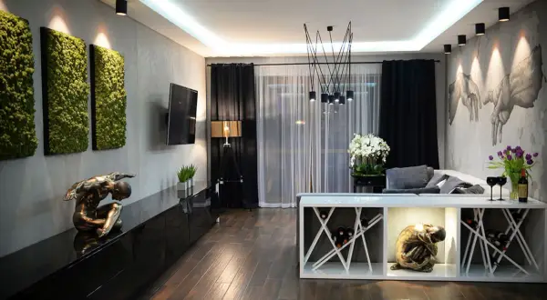 Nowoczesny salon w stylu klasycznym z zielonymi panelami ściennymi, rzeźbami i designerskim oświetleniem.