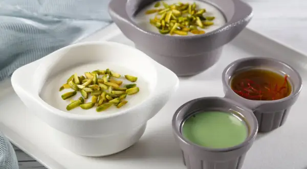 Douceurs crémeuses, pistaches croquantes et sirops colorés pour une mouhalabieh recette parfaite.