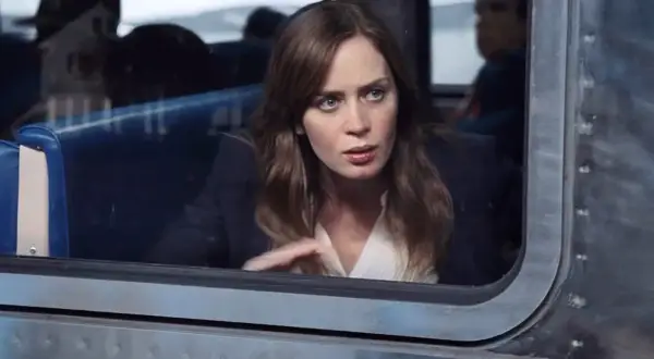 Emily Blunt w filmie, zamyślona, patrzy przez okno pociągu.