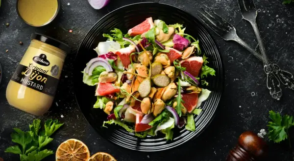 Ensalada fresca con mejillones, pomelo y cebolla morada, aderezada con mostaza de Dijon.