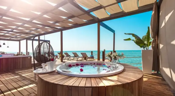 Luksusowy jacuzzi z płatkami róż na tarasie z widokiem na morze. Idealne miejsce na relaks w stylu ultra all inclusive.