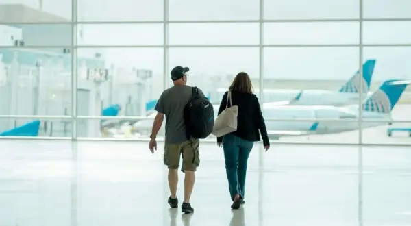 Para idzie przez lotnisko, w tle samoloty United Airlines. Może to ich pierwszy lot czeskimi liniami lotniczymi.