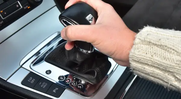 Dłoń na lewarku DSG, pokazująca jak jeździć automatem. Widoczne przyciski ESP, Auto Hold i wybór biegów P, R, N, D, S.