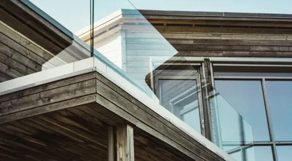 Fachada moderna con madera resistente y cristal.