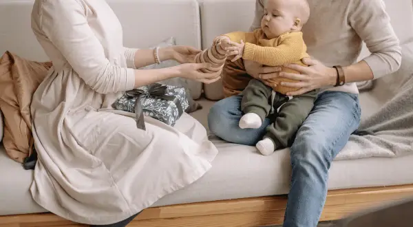 Un couple heureux profite de son enfant, un cadeau emballé à côté.