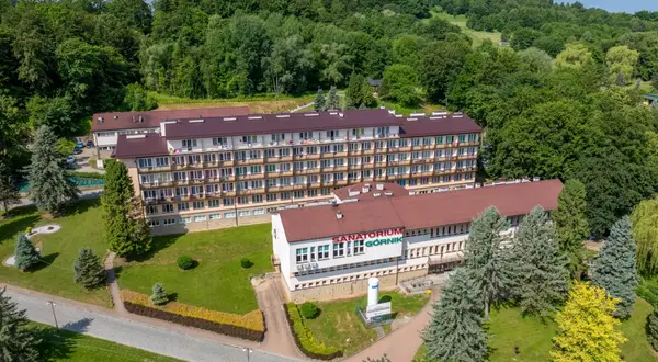 Sanatorium Górnik w Iwoniczu Zdroju, otoczone zielenią, zaprasza na wypoczynek.