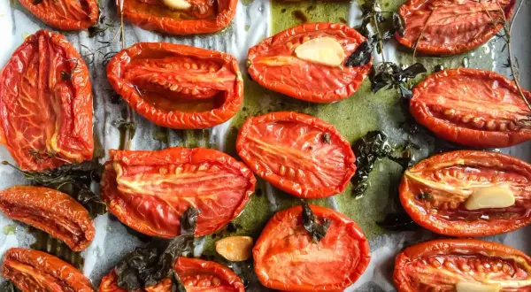 Tomates au four, coupées en deux, rôties avec de l'ail et des herbes, leur chair concentrée et savoureuse.