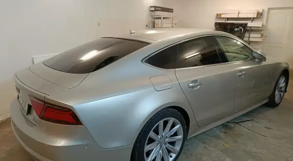 Srebrne Audi A7 z przyciemnione szyby stoi w garażu.