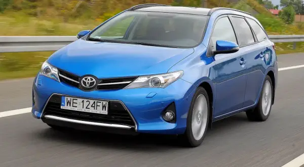 Niebieski Toyota Auris 2015 na drodze, z rozmytym tłem.