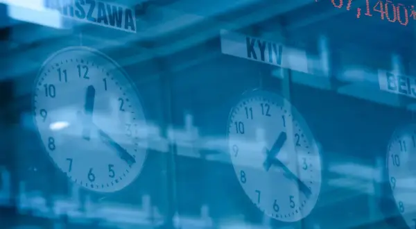 Zegary pokazujące czas w Warszawie i Kijowie, a nad nimi kursy akcji.