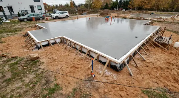 Świeżo wylany fundament pod dom szkieletowy, gotowy na kolejne etapy budowy.
