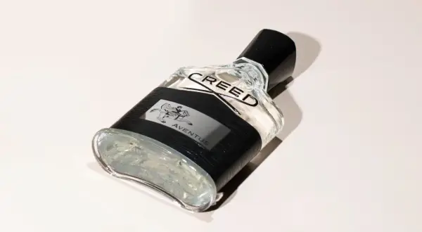 Elegancka butelka perfum Aventus Creed z czarną opaską i wizerunkiem jeźdźca.