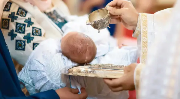 Chrzest święty to początek nowej drogi. Woda obmywa niemowlę, symbolizując oczyszczenie i dar łaski.