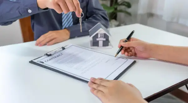 Firma del contratto di compravendita immobiliare con consegna delle chiavi. La procura generale notarile è un atto fondamentale.