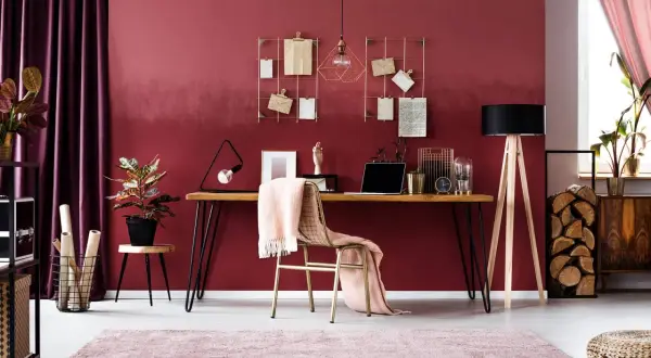 Ein Arbeitsplatz mit einem Schreibtisch, einem Stuhl mit rosa Decke und einer Wand in englisches rosenrot kombinieren.