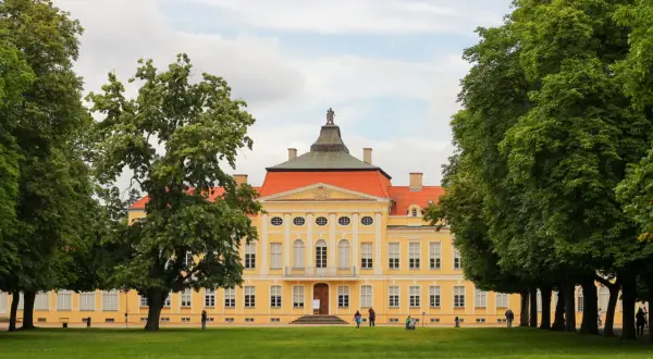 Pałac w Kórniku, jedna z atrakcji wokół Poznania, otoczony zielenią.