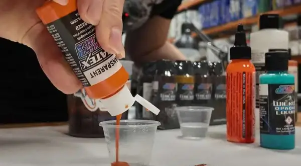 Peinture trop épaisse ? Diluez-la avec précaution pour un rendu parfait. Des flacons de peinture colorée sont visibles.
