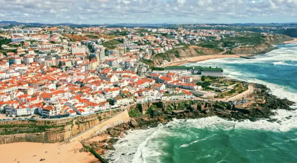 Malownicze portugalia plaże z białymi domami i czerwonymi dachami, wpadające do turkusowego oceanu. Widok z lotu ptaka na wybrzeże.
