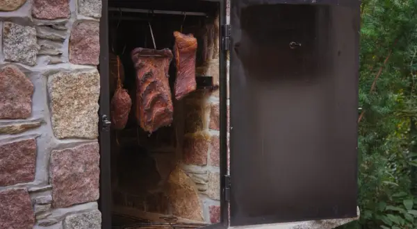 Wędzonki wiszące w kamiennej wędzarni. Tak, można wędzić na podwórku, tworząc pyszne domowe wyroby.
