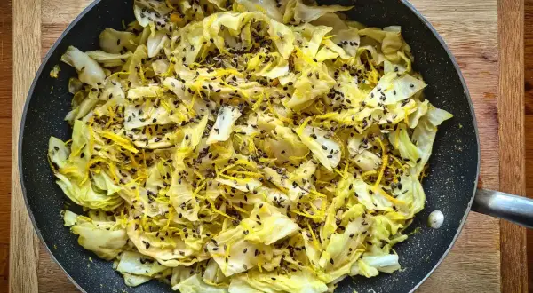 Stekt spetskål med citronskal och svarta sesamfrön i en stekpanna. Enkel och god rätt att grilla spetskål.