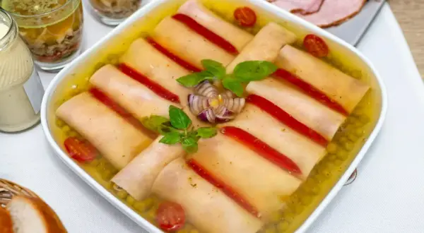 Szynka w galarecie z groszkiem, papryką i pomidorkami. Obok majonez, pieczywo i plastry wędliny.