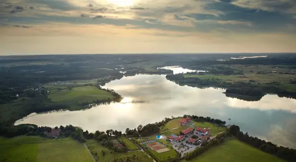 Malownicze jezioro na Mazurach z kompleksem wypoczynkowym i kortami tenisowymi. Idealne miejsce na nietypowe atrakcje Mazury.