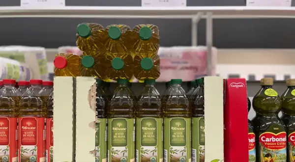 Botellas de aceite de oliva en estanterías. Las desventajas del aceite de oliva, como su precio, pueden ser un factor a considerar al comprar.