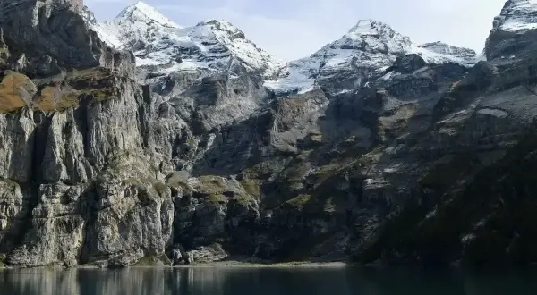 Majestatyczne Tatry Wysokie, ośnieżone szczyty odbijające się w spokojnej tafli jeziora.