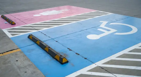 Niebieski pas z symbolem wózka inwalidzkiego i różowy z postacią ludzką. Czy parking dla niepełnosprawnych jest płatny?