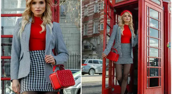 Kobieta w czerwonym beretcie i kratkowanej spódniczce pozuje przy budce telefonicznej, tworząc klasyczny london look.