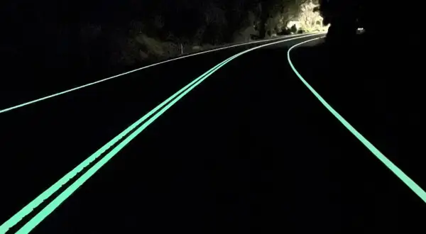 Route de nuit avec marquage lumineux vert, un logo marquage ce discret sur le côté.