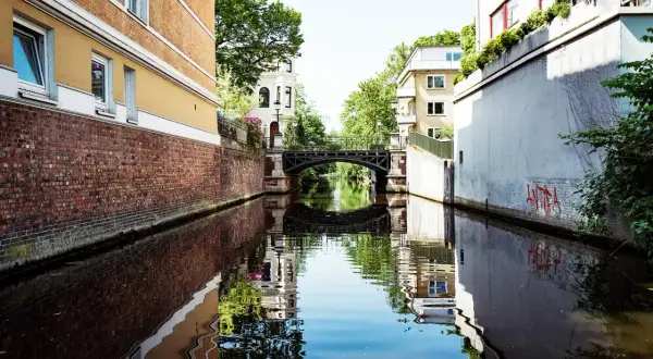 Kanal mit Brücke, reflektiert im Wasser. Ein idyllischer Blick auf den Alster Jungfernstieg, Hamburg.