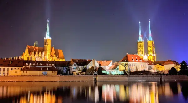 Beleuchtete Kathedralen spiegeln sich im Wasser. Ein perfekter Anblick nach einer Wrocław free walking tour.