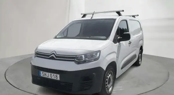 Vit Citroën Berlingo, en pålitlig begagnad transportbil med takräcke, redo för nya äventyr.
