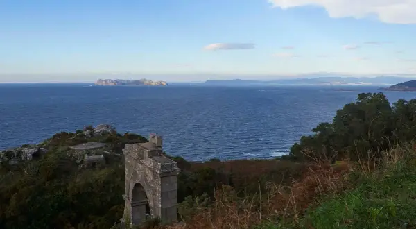 Ruinas de un antiguo faro silleiro, con el mar azul y las islas Cíes al fondo.