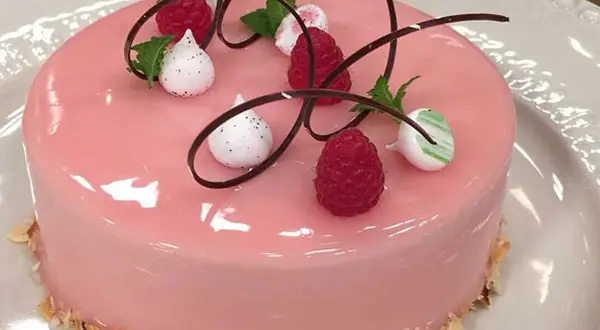 Rosa tårta med spegelglasyr, hallon och maräng. Ett perfekt mirror glaze recept för en festlig dessert.