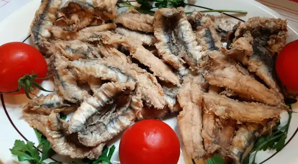 Chrupiące filet anchois z sardeli, podane z pomidorami i natką pietruszki. Pyszna przekąska.