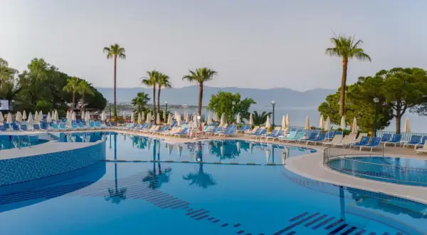 Basen z leżakami i palmami, idealne miejsce na wakacje w Fantasia De Luxe Kusadasi.