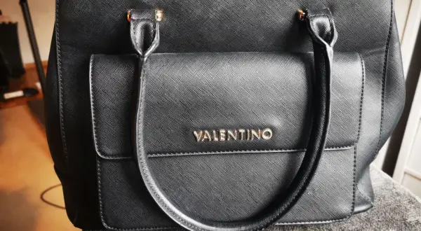 Czarna torebka Valentino z tłoczonym logo. Jak rozpoznać oryginalną? Detale i jakość wykonania są kluczowe.