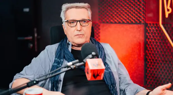 Robert Bernatowicz w studio radiowym, w tle czerwone panele akustyczne. Mówi o swojej żonie.