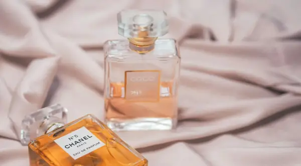 Dwie ikoniczne butelki perfum Chanel, N°5 i Coco Mademoiselle, na jedwabistym tle. Klasyka, która nigdy nie wychodzi z mody, jak Chanel Noir.
