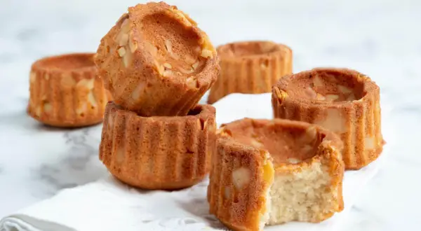 Små, gyllene financiers med mandelbitar, perfekta för ett enkelt financier recept. En tugga avslöjar en saftig insida.