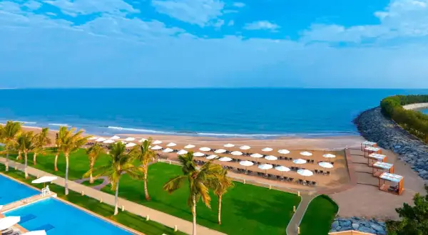 Piękna plaża z palmami i basenem, idealne miejsce na wakacje. Barcelo Mussanah Resort opinie potwierdzają rajski wypoczynek.