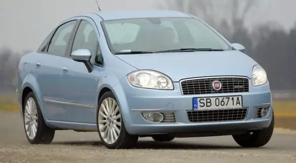 Jasnoniebieski Fiat Linea z polskimi tablicami SB 0671A jedzie po drodze.