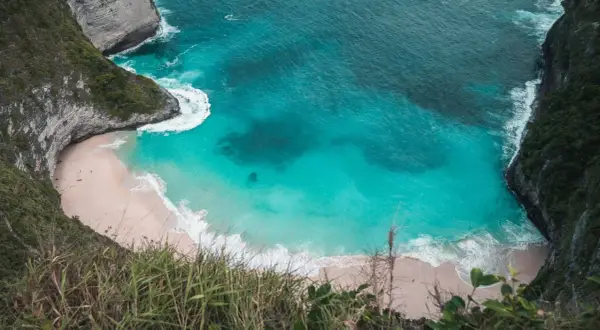 Widok z góry na plażę Kelingking na Nusa Penida z turkusową wodą i klifami.