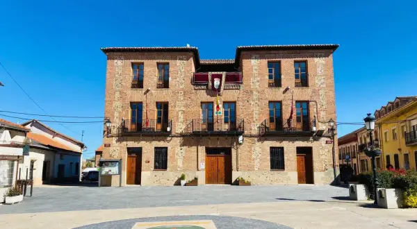 Ayuntamiento de ladrillo en plaza soleada, ideal para descubrir pueblos con encanto para comer cerca de Madrid.