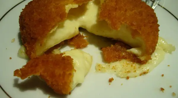 Pyszny camembert w panierce, z którego wypływa gorący, ciągnący się ser. Idealna przekąska na ciepło.