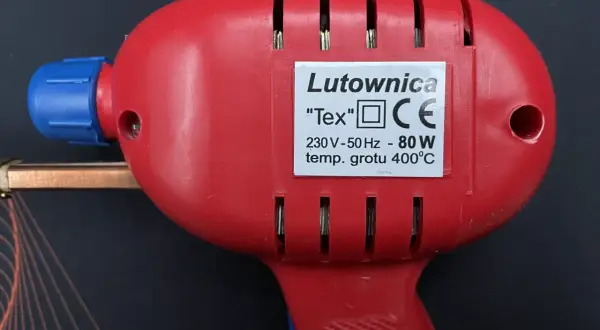 Czerwona lutownica "Tex" z niebieskim elementem, o mocy 80W i temperaturze grotu 400°C. Posiada oznaczenie CE, wskazujące na zgodność z normami bezpieczeństwa, w tym klasy ochronności.
