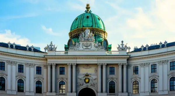 Prunkvolle Kuppel des Hofburg-Palastes in Wien, ein absolutes Wien must see. Majestätische Architektur unter blauem Himmel.